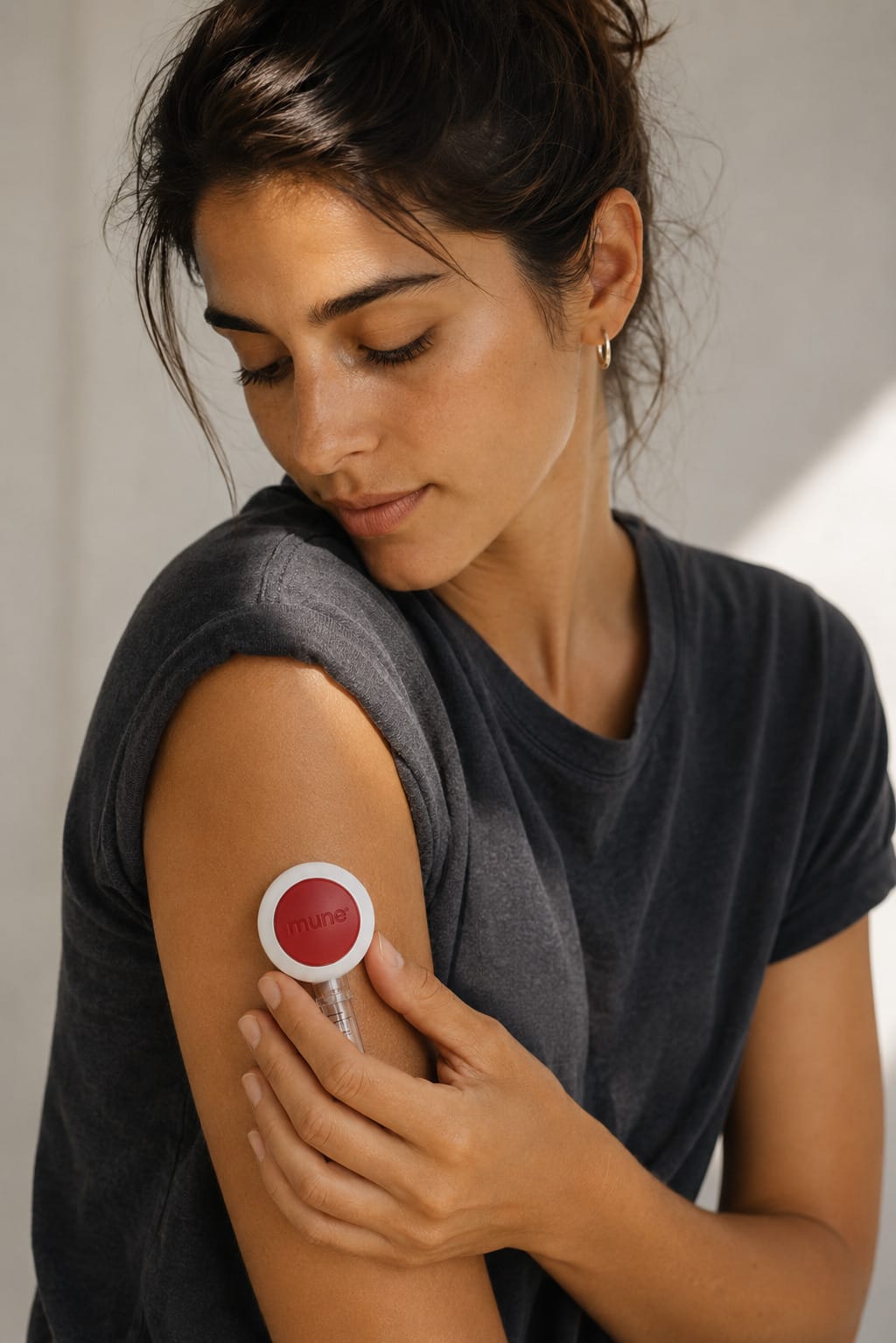 A person pressing the Mune collection device onto their upper arm at home